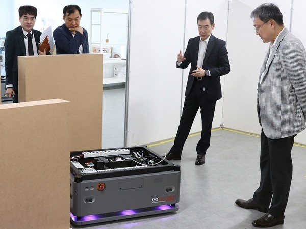 LG유플러스 임장혁 기업신사업그룹장(사진 오른쪽)이 유진로봇의 '고카트250'의 시연 및 설명을 듣고 있는 모습