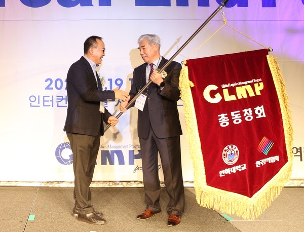 김몽옥 신임회장(오른쪽)이 박부택 전임 회장으로부터 GLMP총동창회기를 전달 받고 있다.